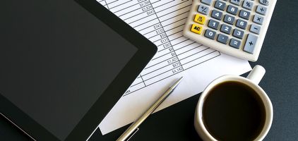 Desk with tablet, calculator, and paperwork